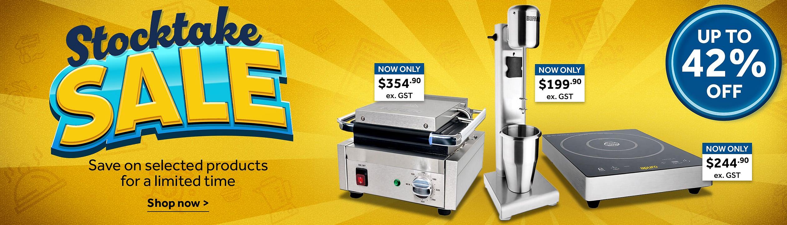 Stock Take Sale. Stocktake Sale promotional banner on a yellow background featuring discounted commercial kitchen equipment. Large text reads 'Stocktake SALE' with 'Save on selected products for a limited time' and 'Shop now'. Products shown include a panini grill priced at $354.90 ex. GST, a stick blender priced at $199.90 ex. GST, and an induction cooktop priced at $244.90 ex. GST. A blue badge on the right states 'Up to 42% off. Shop now >