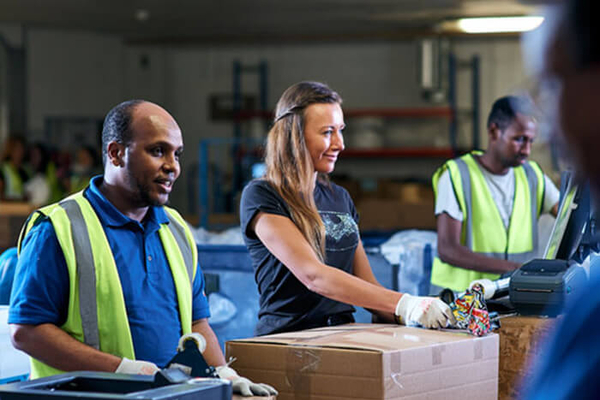 3 people in a warhouse packing boxes