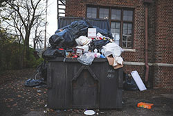 An Industrial Bin Filled With Huge Amounts Of Waste And Bin Bags