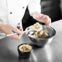 Chef Chris John spoons the pie filling into the pastry case