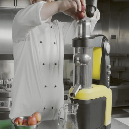 Chef Chris John adds whole apples to a juicer