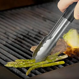 Chef Chris John cooks the lamb chops on a grill