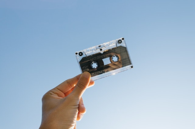 cassette held in the air with blue sky in background