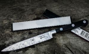 black handled chefs knife resting on stone